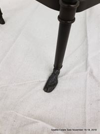 Patinated bronze and glass side table with hand and feet details.