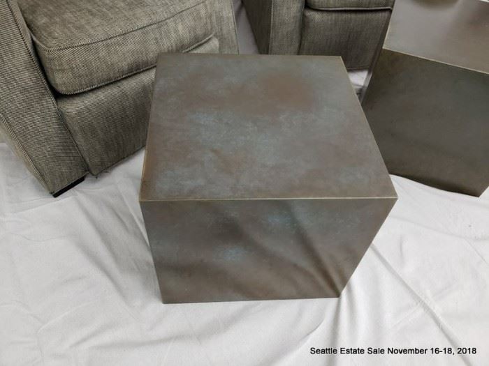 Upholstered club chair.
Patinated bronze cube-form side table.