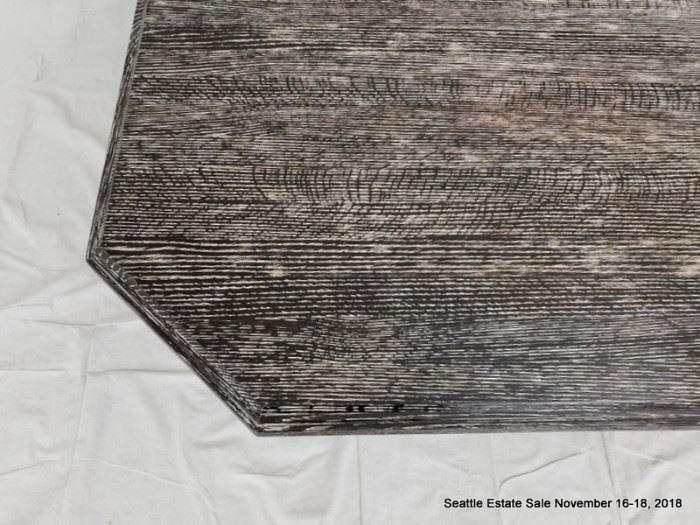 Rectangular cut-corner pedestal table with black and white striated cerused wood finish.