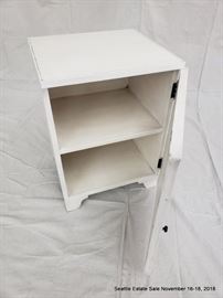 Mirrored-front single door cabinet with white finish.