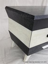 Four drawer side table in black and white cerused wood.