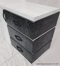Black and white three drawer cerused wood dresser with leather handles.