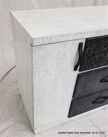 Black and white three drawer cerused wood dresser with leather handles.