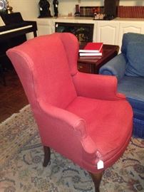 One of two red wing back chairs
