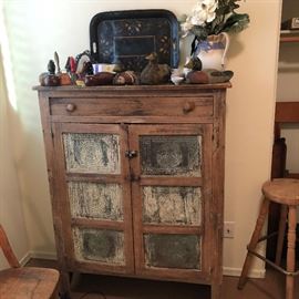 Rustic cabinet with metal inserts in door. 