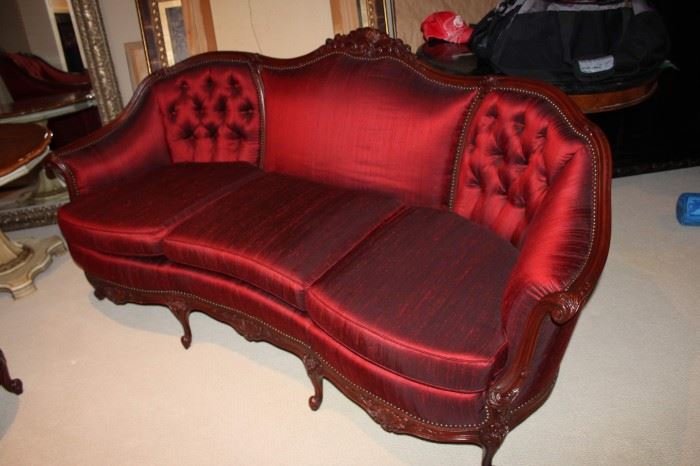 Settee upholstered in red silk with tufted back
