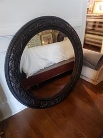 Beveled glass mirror in round, black frame
