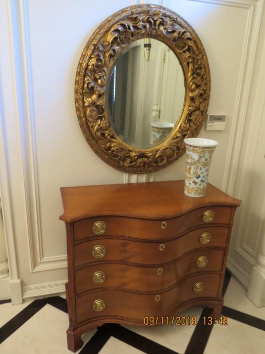 Large round carved frame beveled mirror and a serpentine dresser by Winterthur.