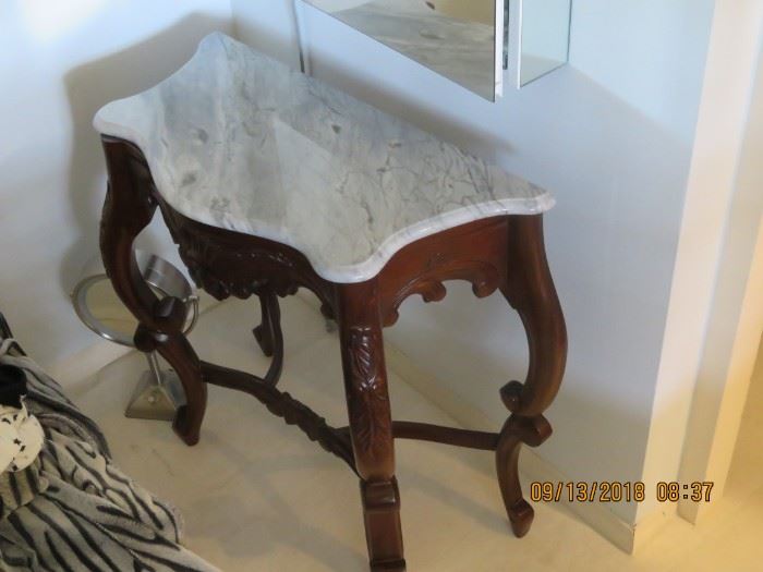 Vanity table with marble and small stool.