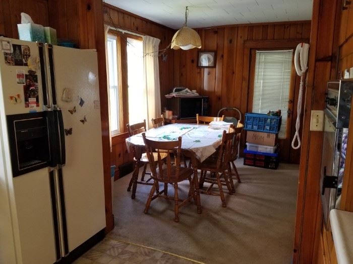 Kitchen table with 6 tables and microwave in corner. 