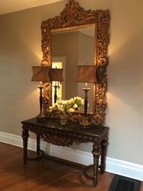 Magnificent marble topped foyer table made in Italy with intricate baroque carvings. This unique piece is 5' long and 20" deep. The table top is 32" off the floor. Retail $3200. Your price is $1400. It pairs beautifully with the baroque mirror! The mirror is 7'-7" tall and 4'-6" wide. The price of the mirror s $500.