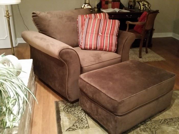 Large upholstered brushed suede easy chair with matching ottoman.