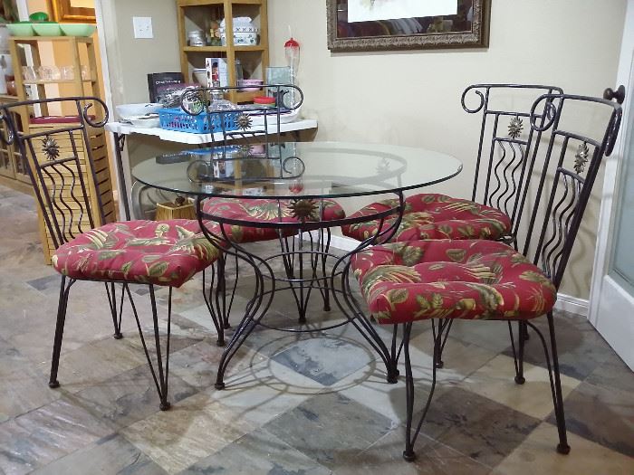 Wrought iron table with glass top - 42in. diameter & 4 wrought iron chairs