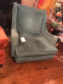 A mid-century lounge chair with a round ottoman.