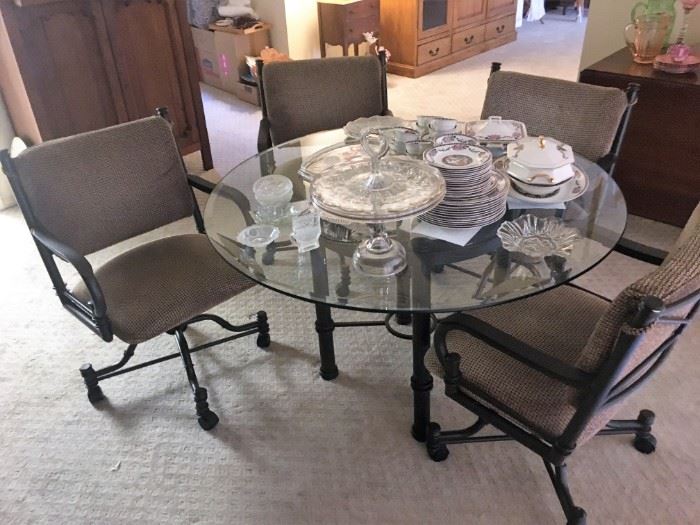 metal and glass top dining table with 4 chairs with rollers