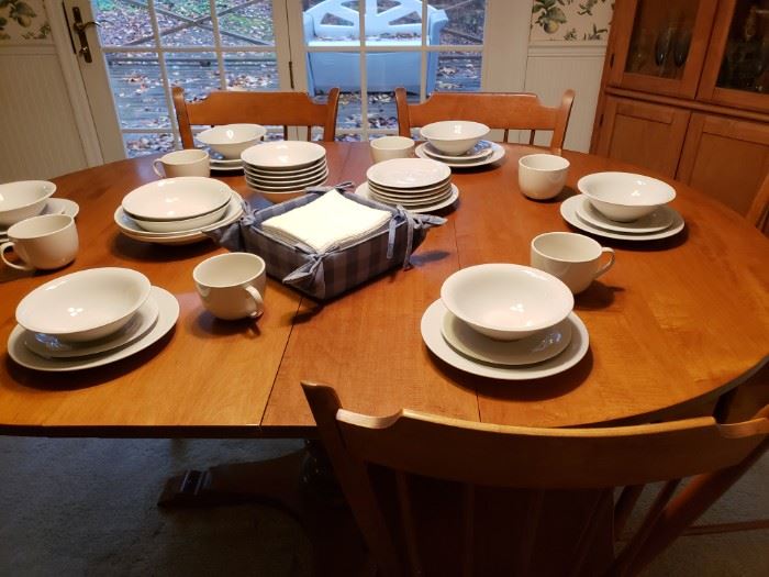 Dining room table and chairs and dinnerware. 