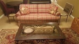 Plaid sofa and oversize glass & metal coffee table
