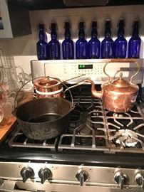 Copper and cast-iron on the stove with blue water bottles