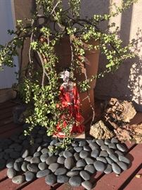 A geisha under the shade of a potted jade plant. 
