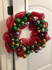 door ready. This bright wreath adorned with Christmas balls and bright red netting