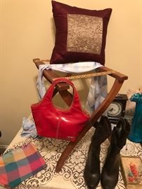 bright red purse hanging on a vintage luggage rack with really cute black leather boots