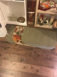 Rugs in hallway closet along with candles, miscellaneous items