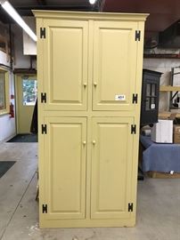 Yellow cupboard with raised-panel doors