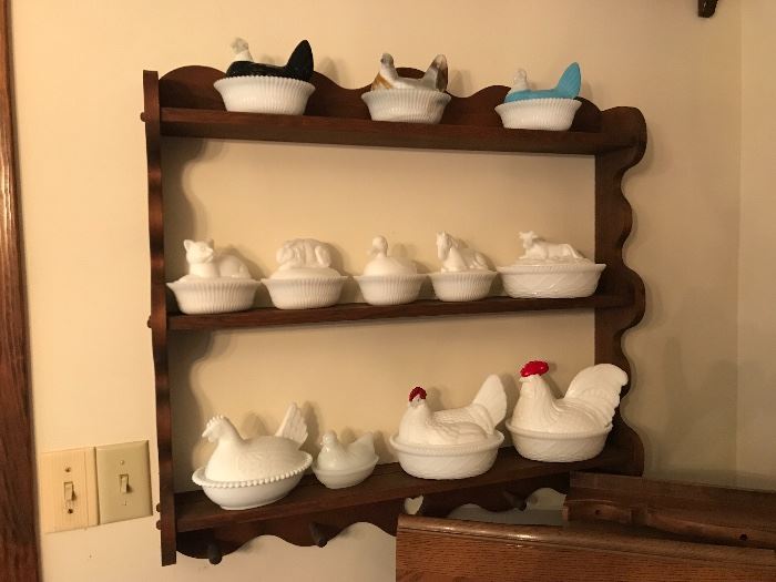 Hens on nest covered dishes (including some other animals on middle shelf)