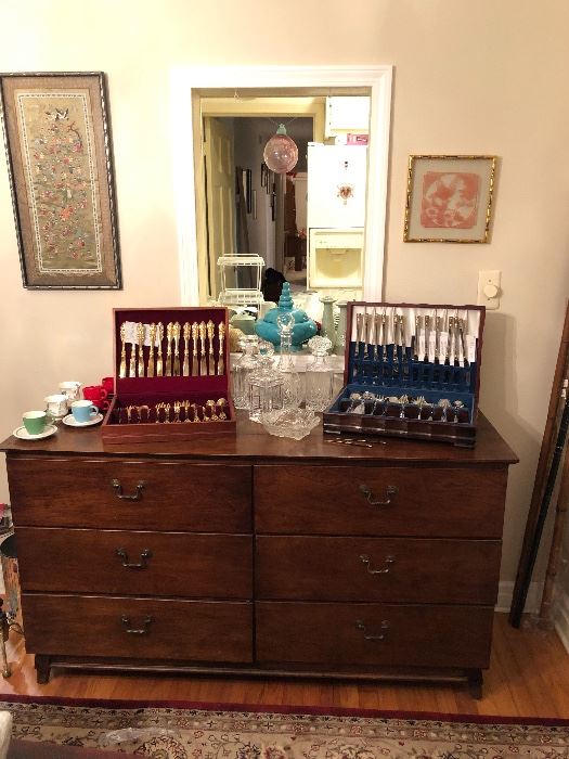 Godinger & Wallace Silverware Sets on an antique chest of drawers. 