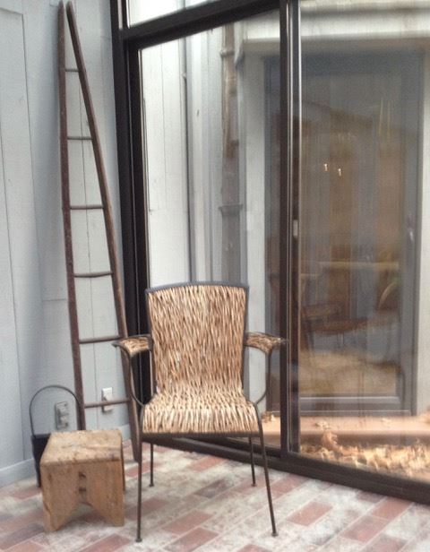 Iron chair with real wood vine seating. Antique apple picking ladder. Foot stool