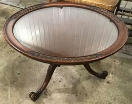 Small, ornate mahogany glass-top coffee table.
