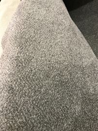 Two very large rolls of gray carpet.