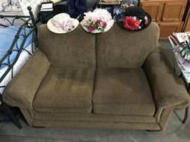 Nice loveseat and a few derby-style/vintage hats.