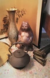 One of two tall brass vases, ceramic bear and cast iron tea kettle.
