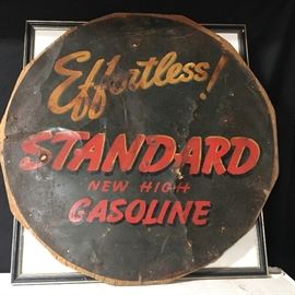 Very old tin sign, "Effortless STANDARD New High Gasoline". Nailed on board.