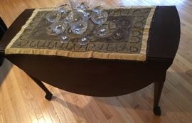 Featured in this picture is a lovely Crystal Clear Glass Decanter with six white champagne glasses. Also features this raw silk table covering. Drop Leaf Mahogany Table is English with Ball & Claw Feet.