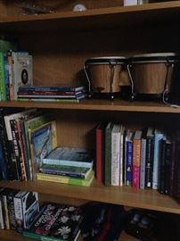 Book case, books, and bongo drums