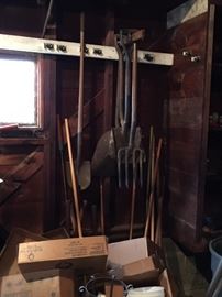 Many antique hand tools, brooms