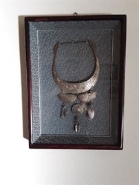 Nickle, Thai necklace, bought in Bangkok and framed in a shadow box with silk background in Korea with a brass hook.