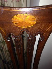 Elegant inlaid wood design on each chair