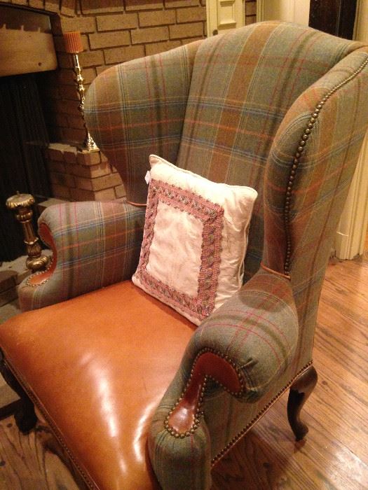 One of two handsome leather and plaid upholstered chairs