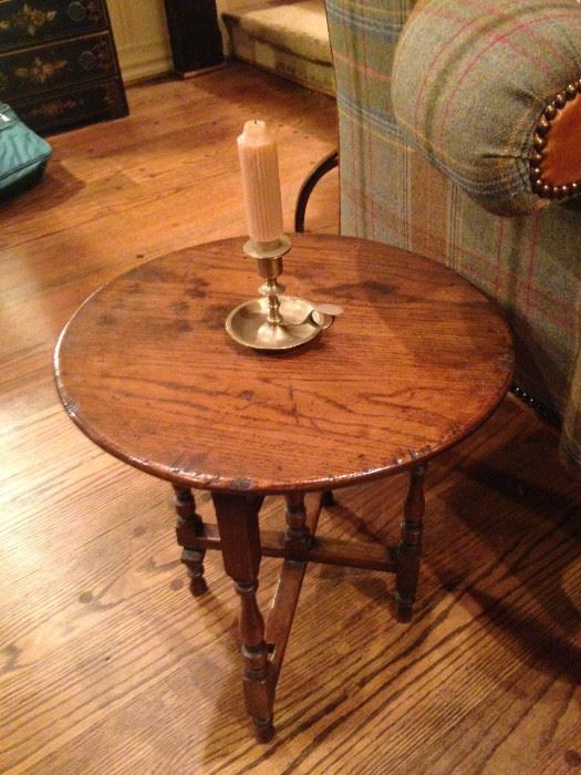 Round antique English oak table; brass candle holder