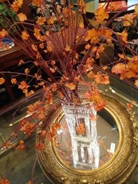 Lovely glass vase; colorful artificial flowering branches; gold framed mirror