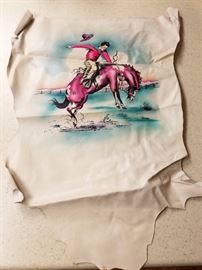 Old painting of a cowboy on hide.