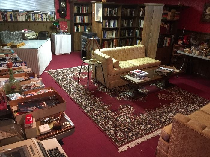 This huge room is full of books, collectibles and a "split sofa"