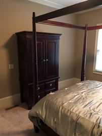 Bedroom suit with canopy bed, armoire and side tables.