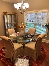 Glass top circular dining table with chairs.