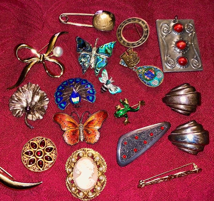 Various vintage costume and silver pins and pendants.