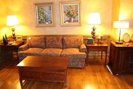Family room has a clean sofa, Bob Timberlake end and coffee tables, brass lamps and oil paintings.