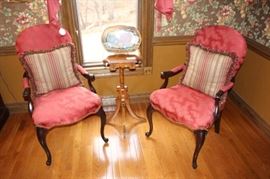 Pair of upholstered armchairs shown with small Victorian era plant stand.
